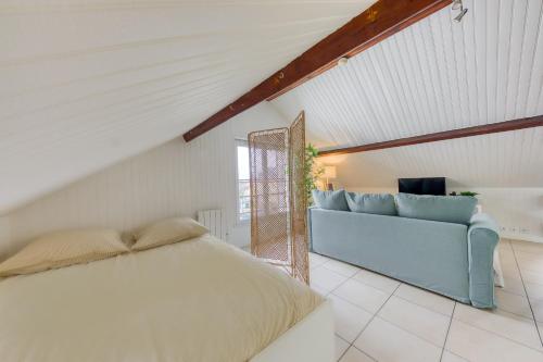 une chambre avec un lit et un canapé bleu dans l'établissement La Cozy Space - 1 min Gare De Corbeil, à Corbeil-Essonnes