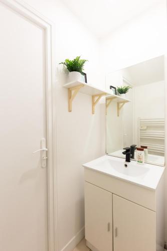 une salle de bain avec un lavabo blanc et un miroir dans l'établissement La Cozy Space - 1 min Gare De Corbeil, à Corbeil-Essonnes