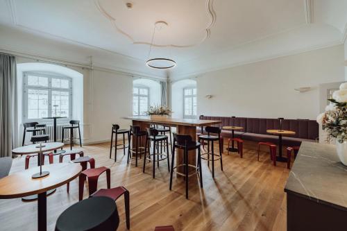 a room with tables and stools in a building at Hotel Kloster Fischingen in Fischingen
