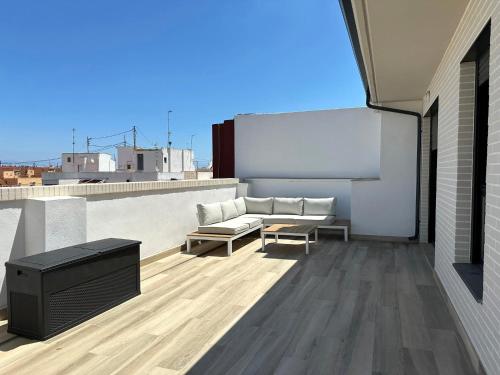 eine Terrasse mit einem Sofa und einem Tisch auf dem Dach in der Unterkunft Pont de Fusta Apartments in Valencia