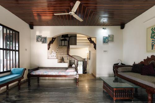 a living room with a ceiling fan and a couch at The Coastal Relic by EWA Properties in Padubidri