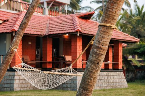 a house with a hammock in front of it at The Coastal Relic by EWA Properties in Padubidri