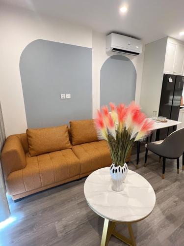 a living room with a couch and a table with flowers at Sora House 5 - Vinhomes Ocean Park in Gia Lâm Pho