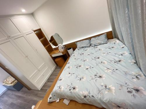 a bedroom with a bed with a white comforter at Sora House 5 - Vinhomes Ocean Park in Gia Lâm Pho