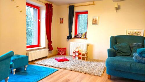 un soggiorno con 2 sedie blu e un tappeto di Five maple home for families and wild nature lovers a Měděnec