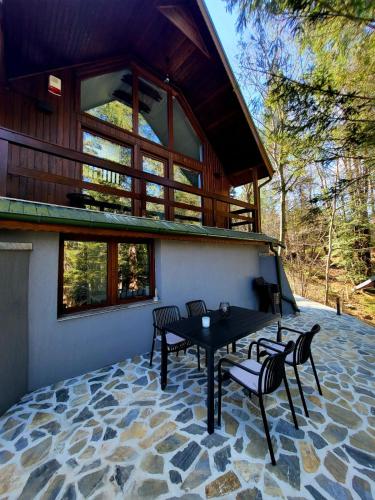 a house with a table and chairs on a patio at Wild House in Sinaia