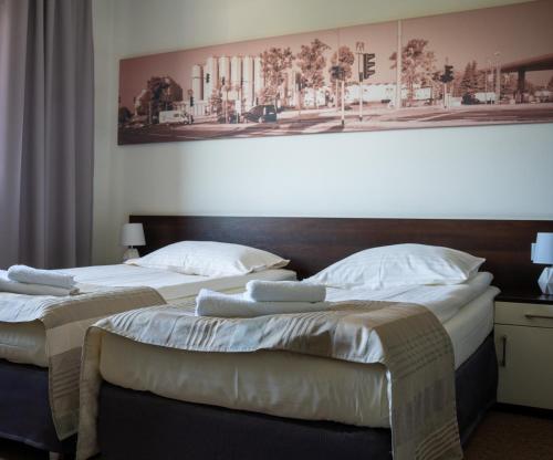 twee bedden in een hotelkamer met een foto aan de muur bij Aparthotel Strefa Premium in Tychy