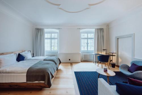 a bedroom with a large bed and a couch at Hotel Kloster Fischingen in Fischingen