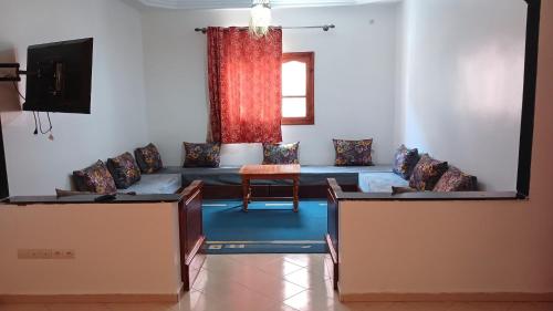 ein Wohnzimmer mit einem Sofa und einem Tisch in der Unterkunft Warzazat Apartments in Ouarzazate