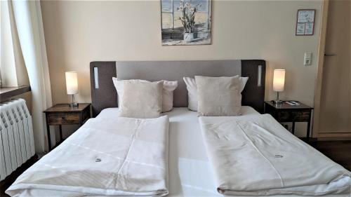 a bedroom with two beds with white sheets and pillows at Altstadthotel Goldene Kugel in Waren
