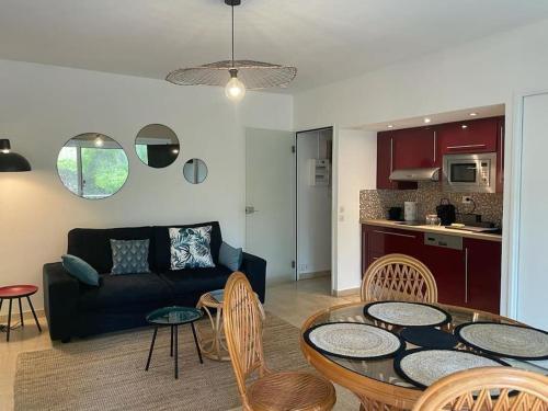 un salon avec un canapé, une table et des chaises dans l'établissement Bandol plage de Renécros, à Bandol