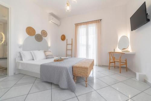 ein weißes Schlafzimmer mit einem Bett und einem Tisch in der Unterkunft Disis Residence in Naxos Chora