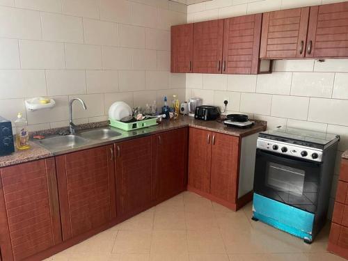 a kitchen with a sink and a stove top oven at Farzus BnB in Sharjah