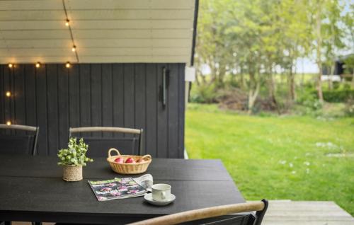 a black table with a bowl of fruit and a basket of fruit at 2 Bedroom Beautiful Home In Thyholm in Thyholm