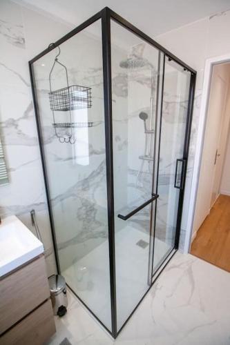 La salle de bains est pourvue d'une cabine de douche en verre. dans l'établissement Brand New Central Cannes Apt 2 min walk to Palais, à Cannes