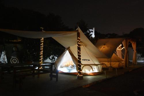 uma tenda com uma lareira à noite em Camping Tents with Garden Hanging Bed em Porto Rafti