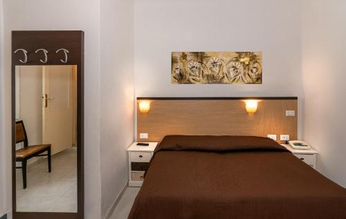 a bedroom with a bed and a painting on the wall at Hotel Rex in Viareggio