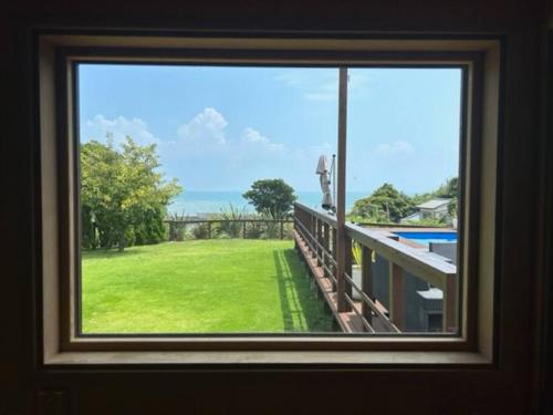 a window view of a yard from a house at コースタルキャビン - シービュー バーベキュー ピザ サウナ プール ホットタブ - Coastal Cabin Chiba - Seaview BBQ PIzza Sauna Pool Hot-tub in Iwada