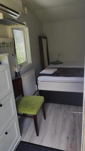 Habitación pequeña con cama y silla. en Minivilla in Gustavsvik Nacka, en Gustavsvik