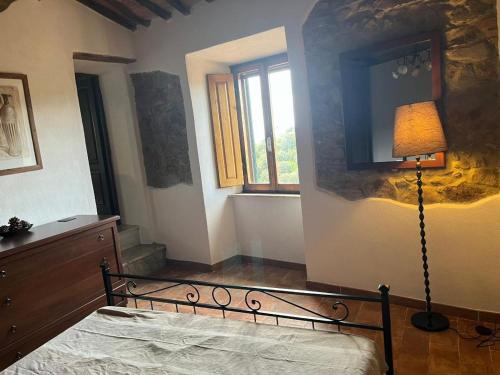 a bedroom with a bed and a lamp and a window at Casa Bella Vista in Pereta