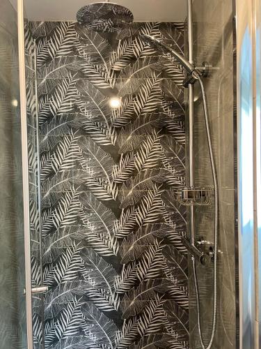 a shower with a black and white wallpaper at 116 The Pond House in Holmfirth