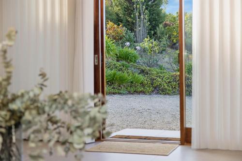 an open door with a view of a garden at Hill Moi Country stay by the Sea in Victor Harbor