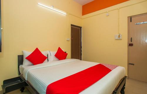 um quarto com uma cama grande e almofadas vermelhas em Flagship Sri Hari Premium Comforts Near Sandhya Digital 4K Theatre em Bangalore