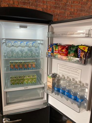 an open refrigerator filled with lots of water and food at Central Sheffield 3BED 3BATH V Pent-Apartment in Sheffield