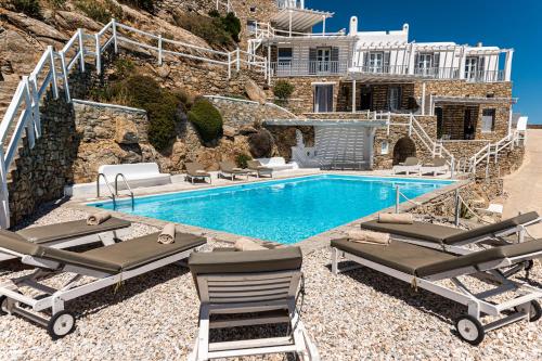 a villa with a swimming pool and a house at Villa Thelgo Mykonos in Psarou
