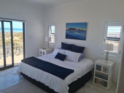 a bedroom with a bed with a view of the ocean at Holiday Beach House in Velddrif