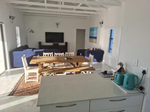 a living room with a wooden table and a couch at Holiday Beach House in Velddrif