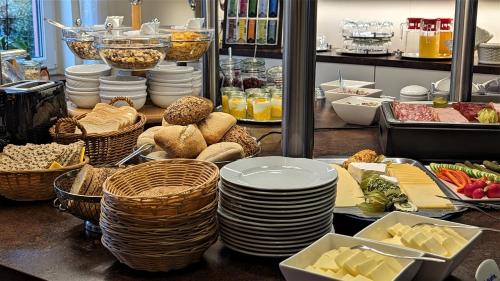 a buffet with plates and baskets of food on a table at Altstadthotel Goldene Kugel in Waren