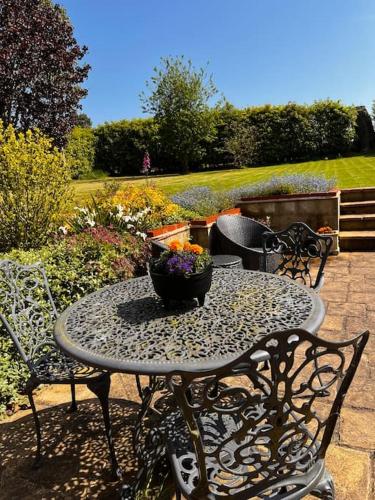 a table with a bowl of flowers on a patio at The Stables, Moulton St Mary in Norwich