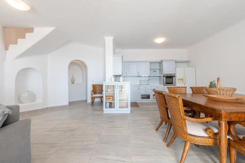a kitchen and dining room with a table and chairs at Villa Thelgo Mykonos in Psarou