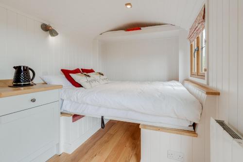 um pequeno quarto com uma cama numa pequena casa em Woodpecker Hill - apple orchard in Alfriston em Alfriston