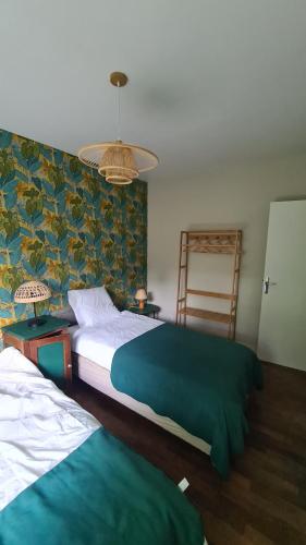 a bedroom with two beds and a wall at LA TANIÈRE in Gueures