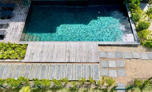 an overhead view of a swimming pool with wooden steps at Summer beachfront apartment in Belle Mare