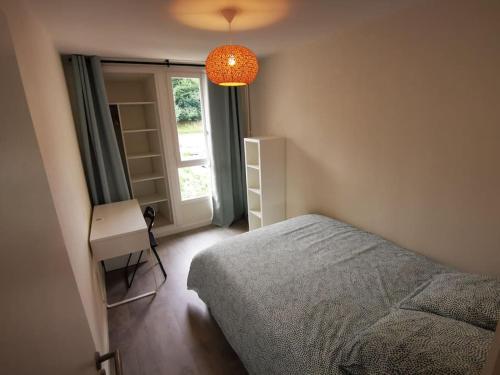 une chambre avec un lit, un bureau et une fenêtre dans l'établissement Appartement grande capacité Bayonne, à Bayonne