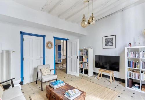 un salon avec un canapé et une télévision dans l'établissement Les Secrets de la rue Dauphine, à Paris