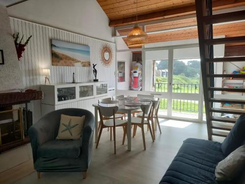 un salon avec une table et des chaises de salle à manger dans l'établissement Ref 031 T3 mezzanine vue mer à louer pour 4-6 personnes, à Arzon