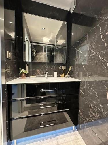 une salle de bain avec un lavabo et un miroir dans l'établissement JOIA PARIS - Vaugirard, à Paris