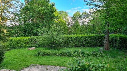 a garden with a bench in the grass at LA TANIÈRE in Gueures
