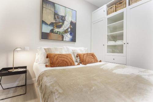 - une chambre blanche avec un lit et un tableau mural dans l'établissement Apartamento Bernabeu Comfort en Madrid, à Madrid