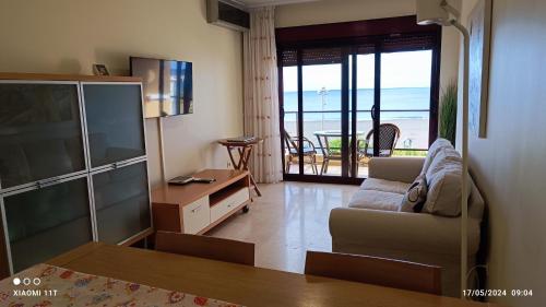 a living room with a couch and a view of the ocean at The Apartment in Gran Tarajal