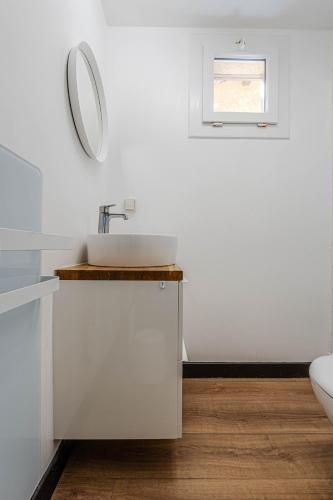 une salle de bain blanche avec un lavabo et un miroir dans l'établissement Appartement avec terrasse/Bord de mer/Idéal SURF, à Seignosse