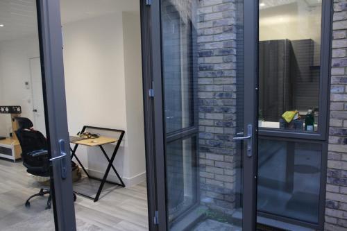 a glass door in an office with a desk at Brand new Greenwich house-Heart of London-Great connections to Central London in London