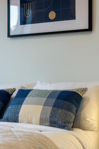 a bed with a pillow and a picture on the wall at City Lights Retreat with Carpark 2 Bed 2 Bath in Christchurch