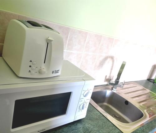 a toaster sitting on a counter next to a sink at Atlantic Point Stunning Sea View in Bundoran
