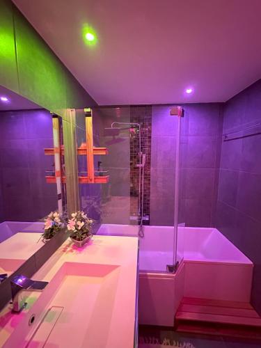 La salle de bains violette est pourvue d'une baignoire et d'une douche. dans l'établissement Superbe 3pièces, balcon, garage, clim, piscine, à Mougins