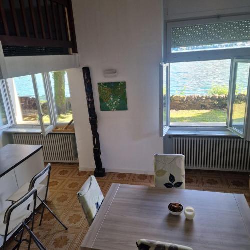 a dining room with a table and two windows at Dream Apartment Room lake 3 in Paradiso